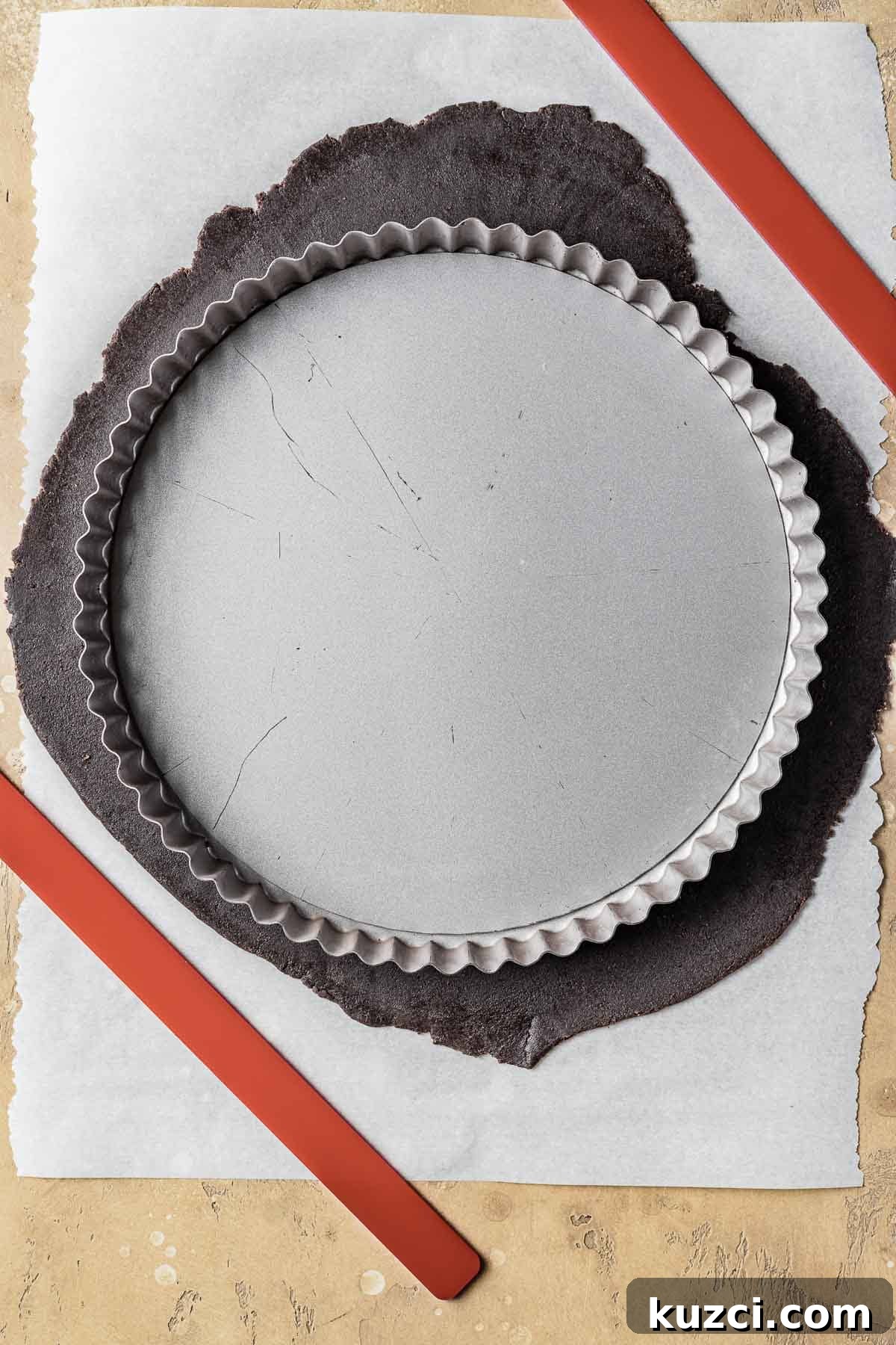 An empty tart pan on top of rolled out dough.