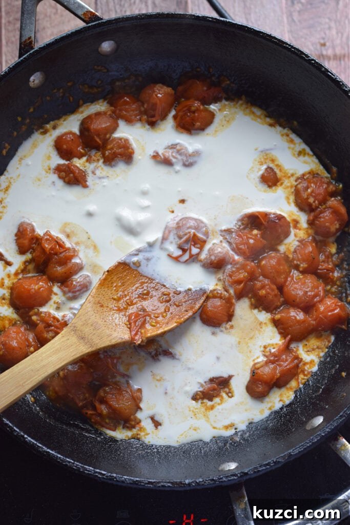 Skillet Chicken with Tomatoes and Spinach Recipe 11 Adding cream to cherry tomatoes in a skillet.