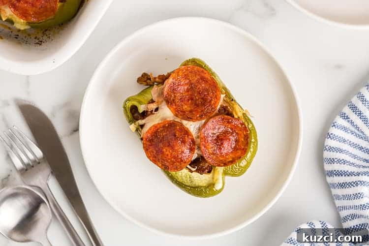 Keto Pepperoni Pizza Stuffed Peppers 6 overhead view of single low carb stuffed peppers on a white plate