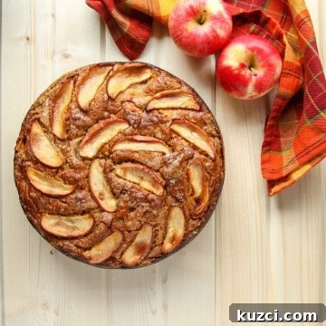 An apple sitting on top of a wooden cutting board, with Cake