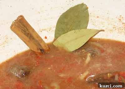 Adding bay leaf and cinnamon to beef with quince for greek recipe moschari me kydonia.