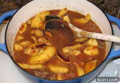 Adding quince to the pot of beef stew with quince, the greek recipe for moschari me kydonia.
