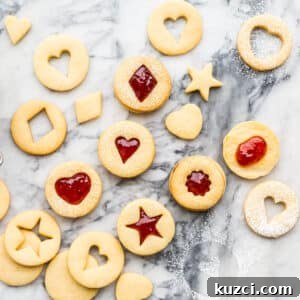Jam-Filled Shortbread Cookies Recipe 7 Homemade jam-filled shortbread cookies with little cutout windows shaped like hearts and stars.