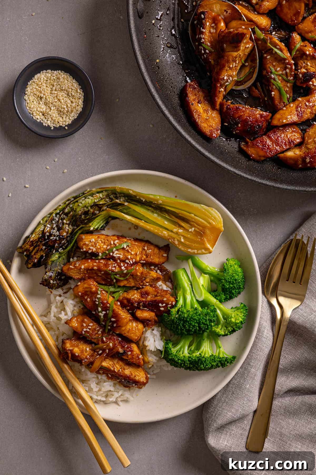 Honey Ginger Glazed Chicken Recipe 11 A plate with honey ginger chicken, rice, broccoli and roasted bok choy on a gray table.