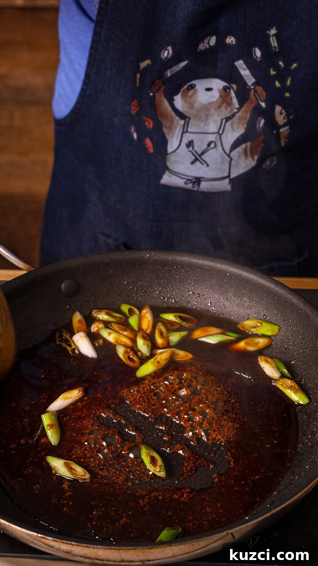 Honey Ginger Glazed Chicken Recipe 8 Honey ginger sauce getting reduced in a nonstick skillet with sliced scallions.