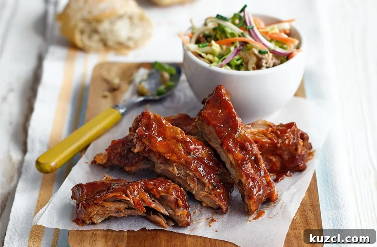 A plate of cut teriyaki ribs with a bowl of coleslaw