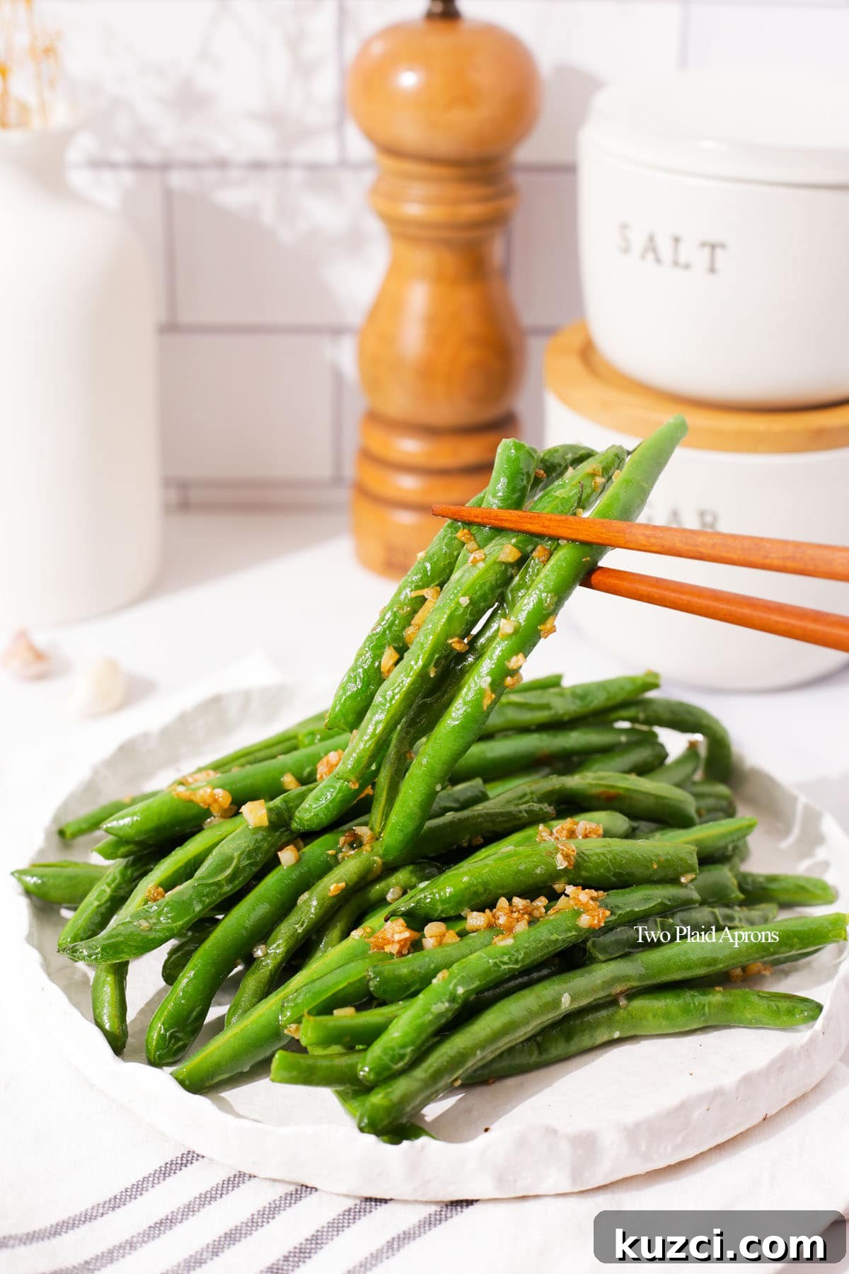 Sticky Char Siu Chicken: Cantonese BBQ Chicken Recipe 4 Picking up green beans with garlic with chopsticks.