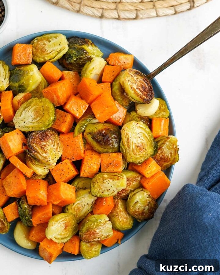 Bowl of brussel sprouts and sweet potatoes with a fork.