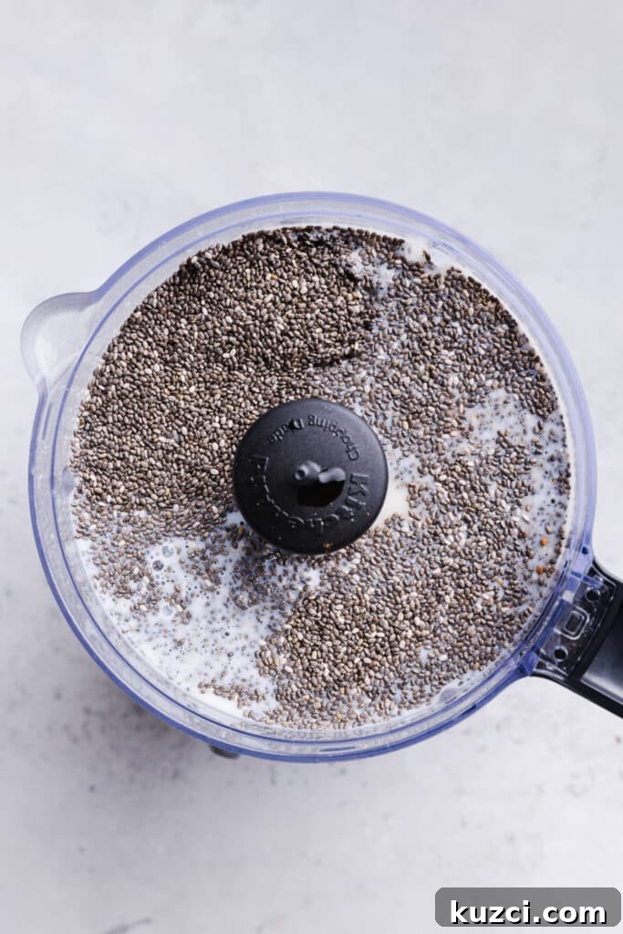 Chia seed pudding ingredients in a food processor about to be blended.