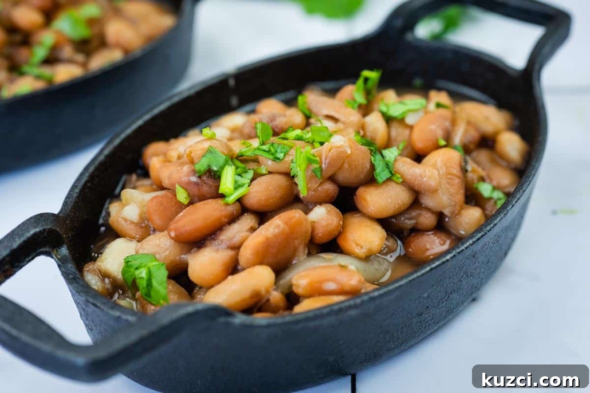 A black oval dish filled with Instant Pot Charro Beans topped with chopped cilantro.