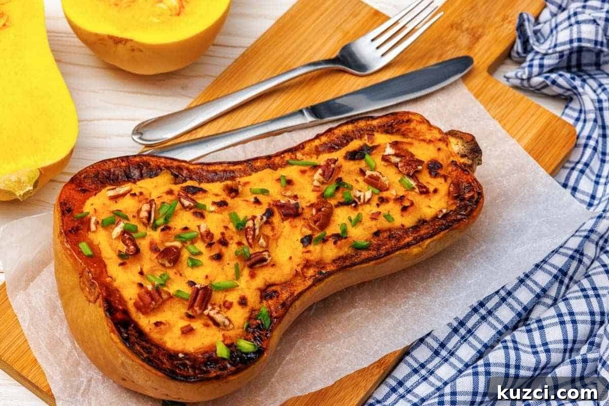 A baked Butternut Squash Mash with Parmesan, garnished with chopped nuts and herbs, served on parchment paper, accompanied by a fork, knife, and a blue checkered cloth.