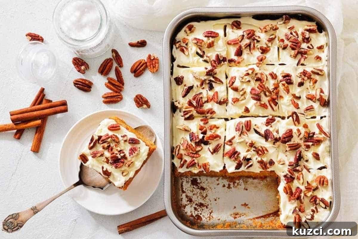 A pan of carrot cake bars topped with chopped pecans, with one slice served on a plate beside cinnamon sticks and whole pecans.