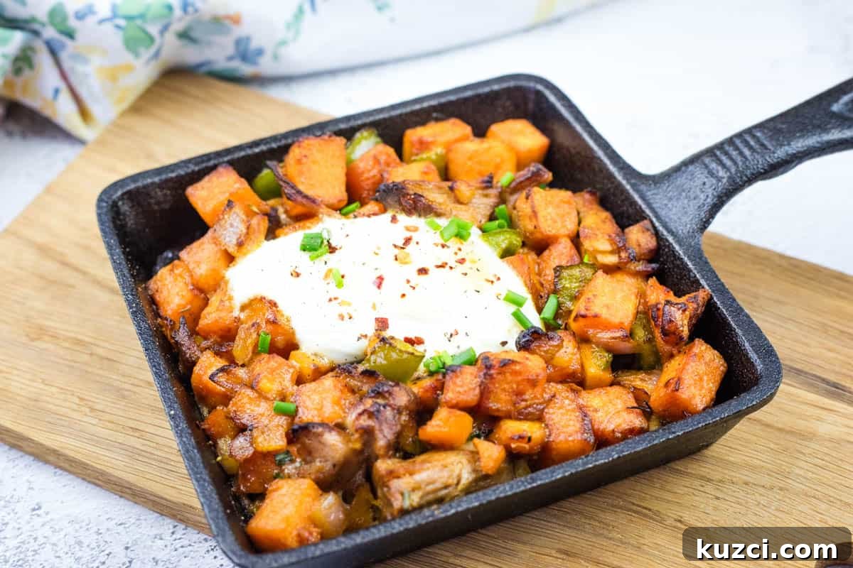 Cast iron skillet with sweet potato hash with pulled pork and garnished with chopped chives.