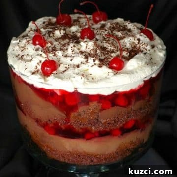 Easy Black Forest Trifle in a clear glass trifle bowl with a black cloth background