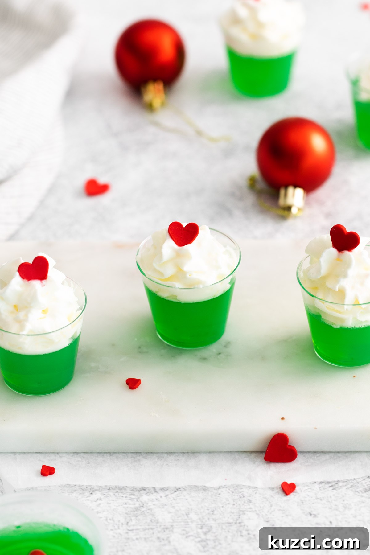 Vodka Cocktail Recipes: Classic and Creative Drinks to Try 9 the completed grinch jello shots on a tray with red and green decorations