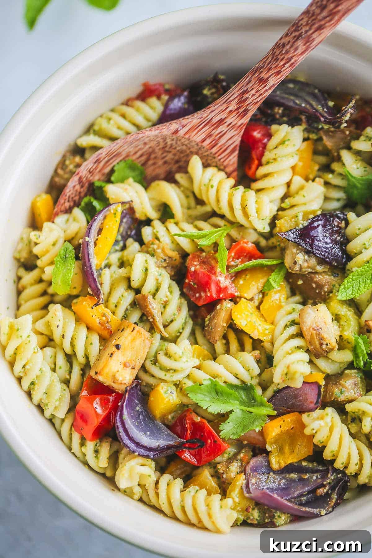 Vegan Pasta Salad served in a bowl, with a serving wooden spoon