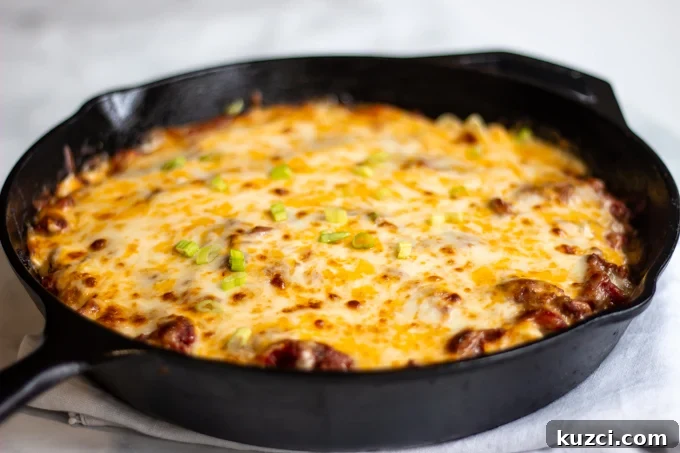 The finished cheesy hamburger casserole topped with sliced green onions 