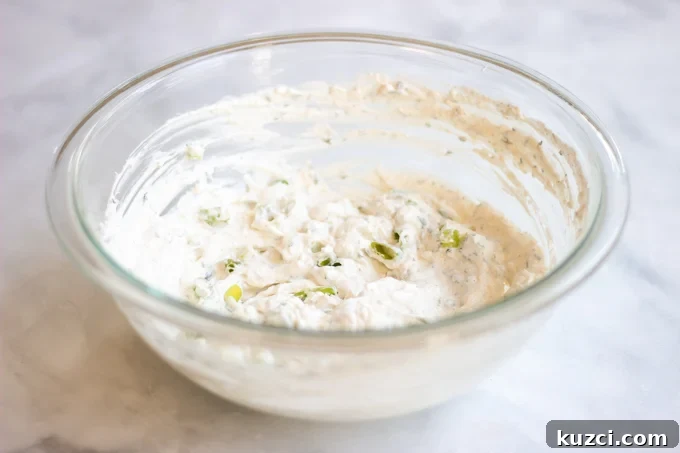 the sour cream, cream cheese and parmesan cheese mixed together in bowl.