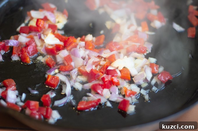 sauteed onions, red bell peppers in skillet cooking 