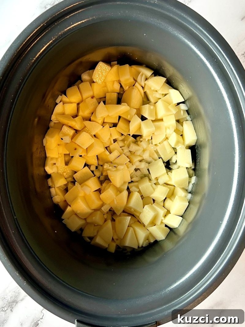 Potatoes, onions, and garlic being prepared for slow cooker chowder