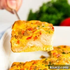 A hand lifting a a piece of biscuit casserole with eggs from the pan.