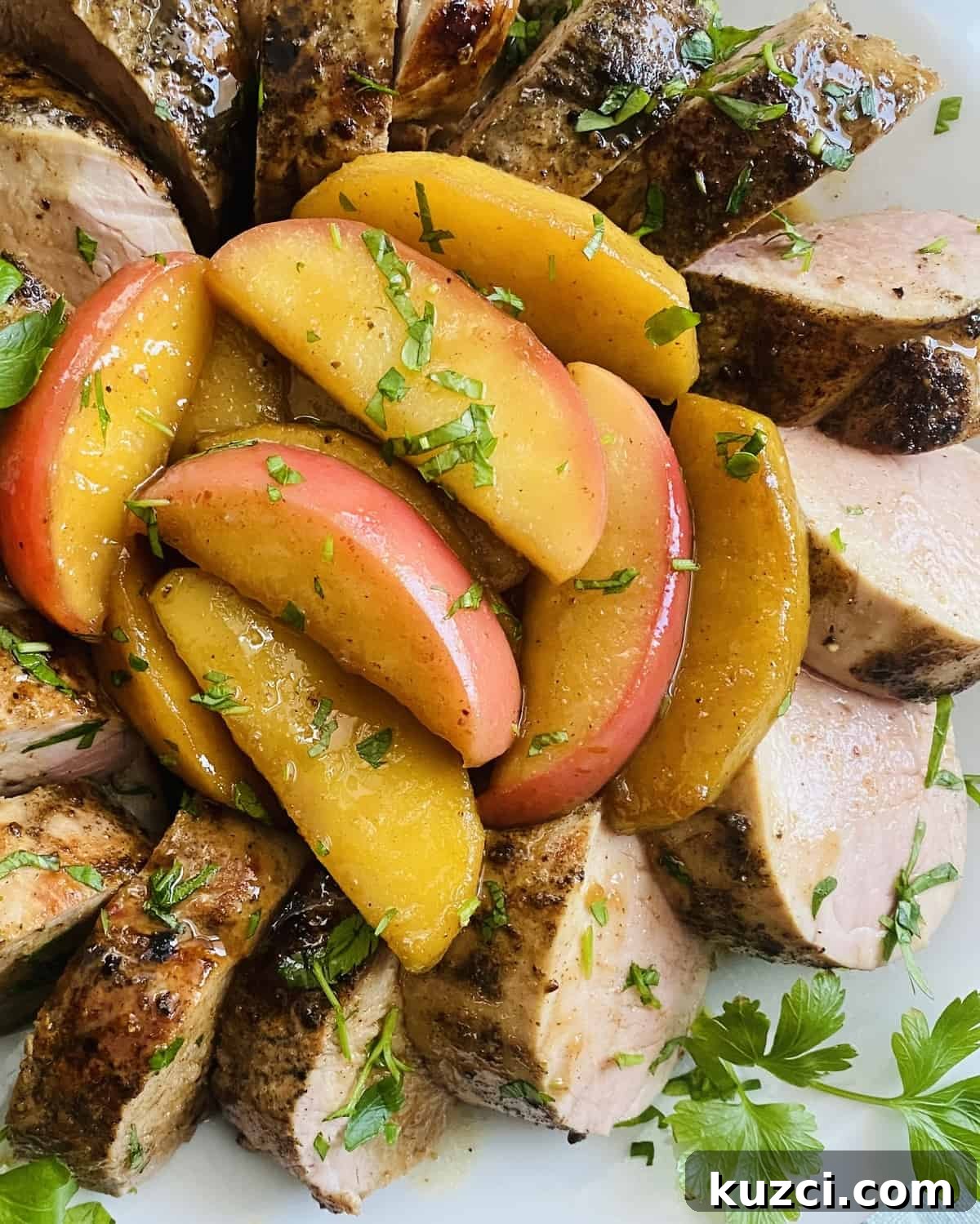 Maple Glazed Pork Tenderloin with Apples 2 Sautéed apples with maple glaze and pork tenderloin on a plate.