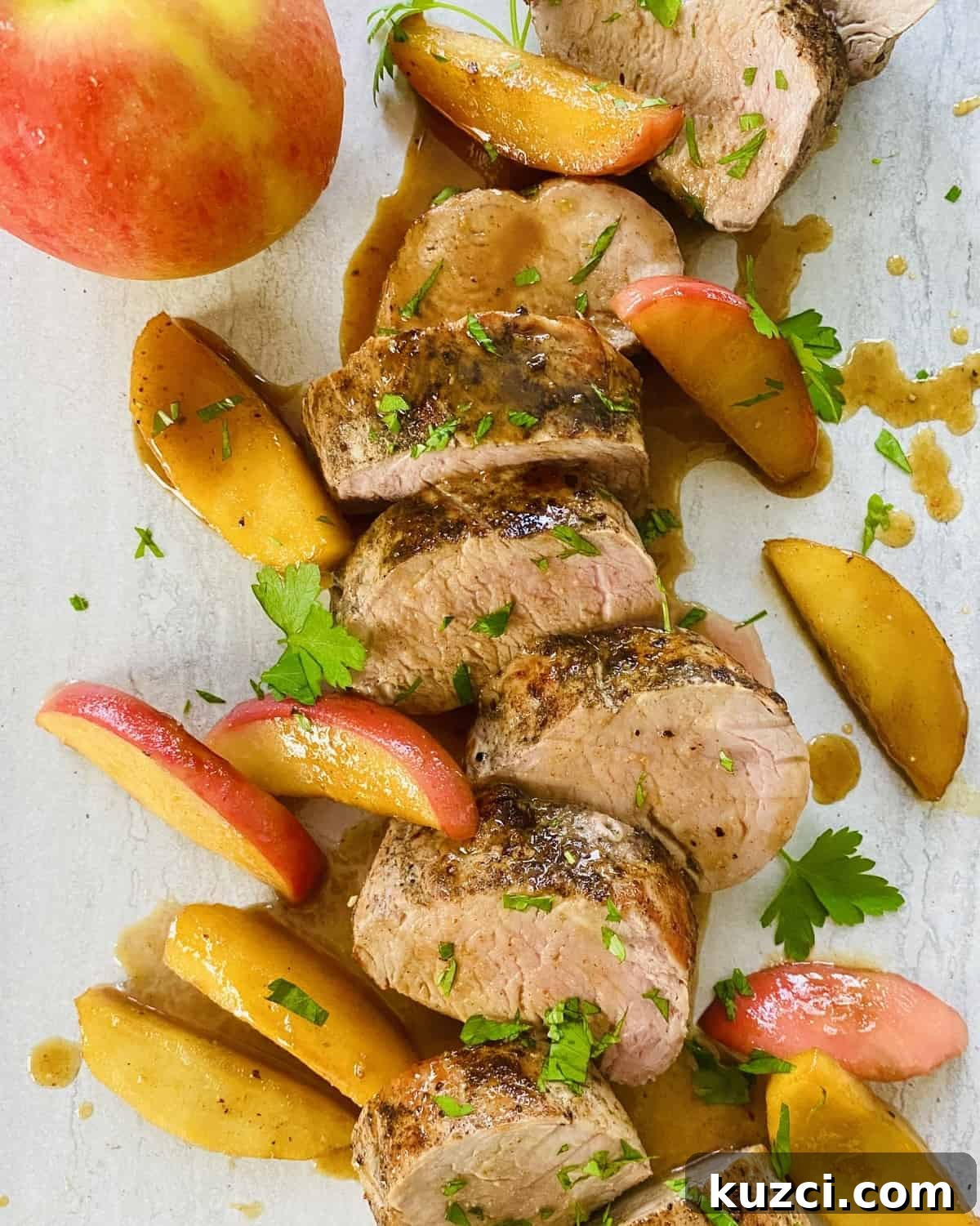 Maple Glazed Pork Tenderloin with Apples 9 A sliced pork tenderloin drizzled with maple glaze and served with sautéed apples.