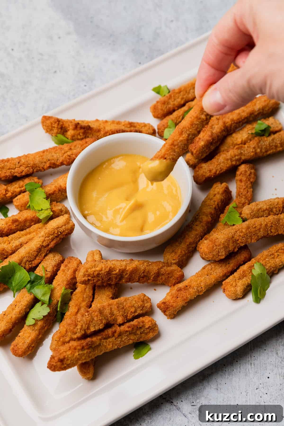 dipping chicken fries into honey mustard.