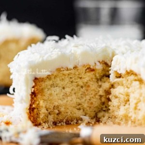 Moist Single Layer Coconut Cake Recipe 11 Sliced single layer coconut cake with black background.