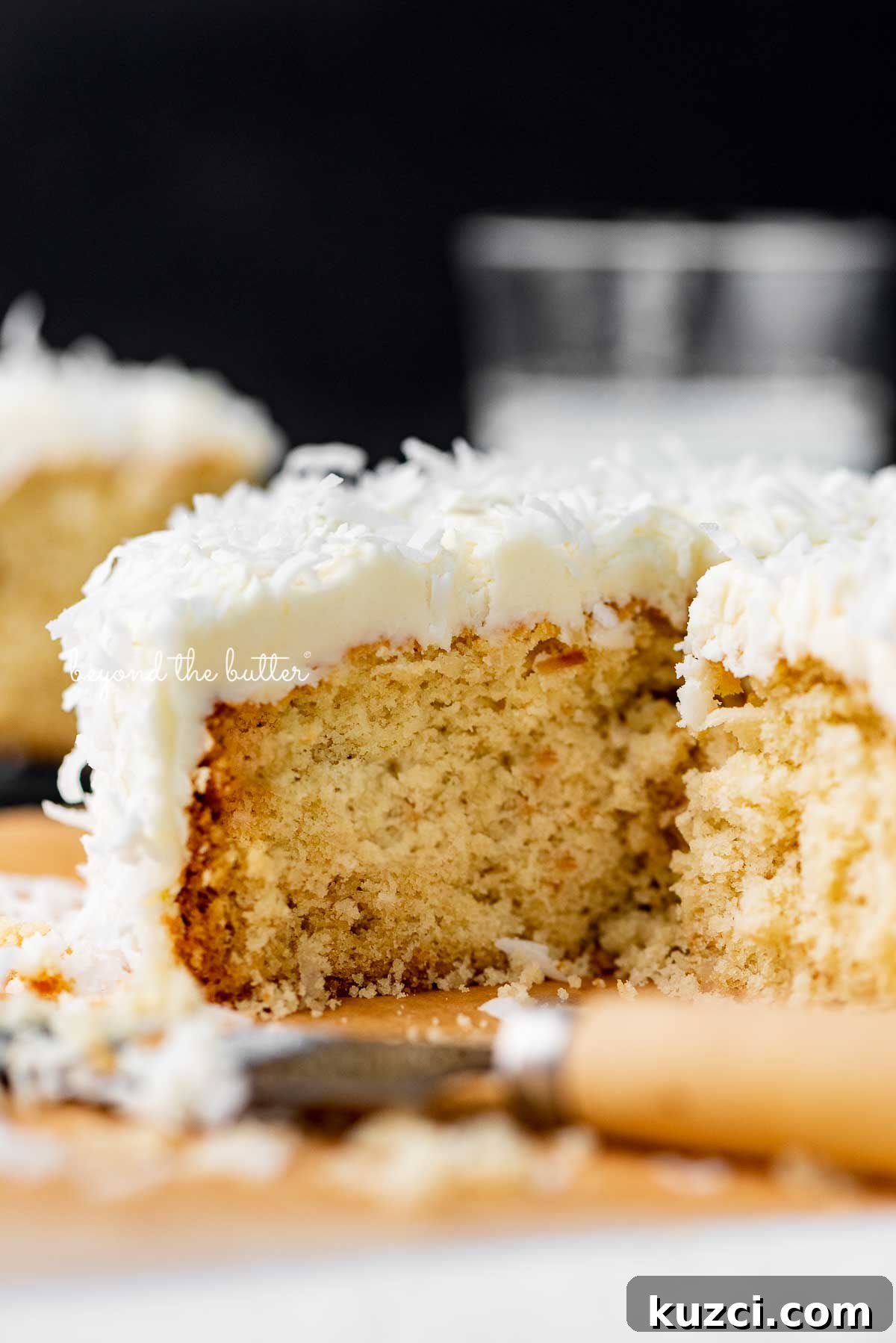 Moist Single Layer Coconut Cake Recipe 4 Sliced single layer coconut cake with black background | © Beyond the Butter®