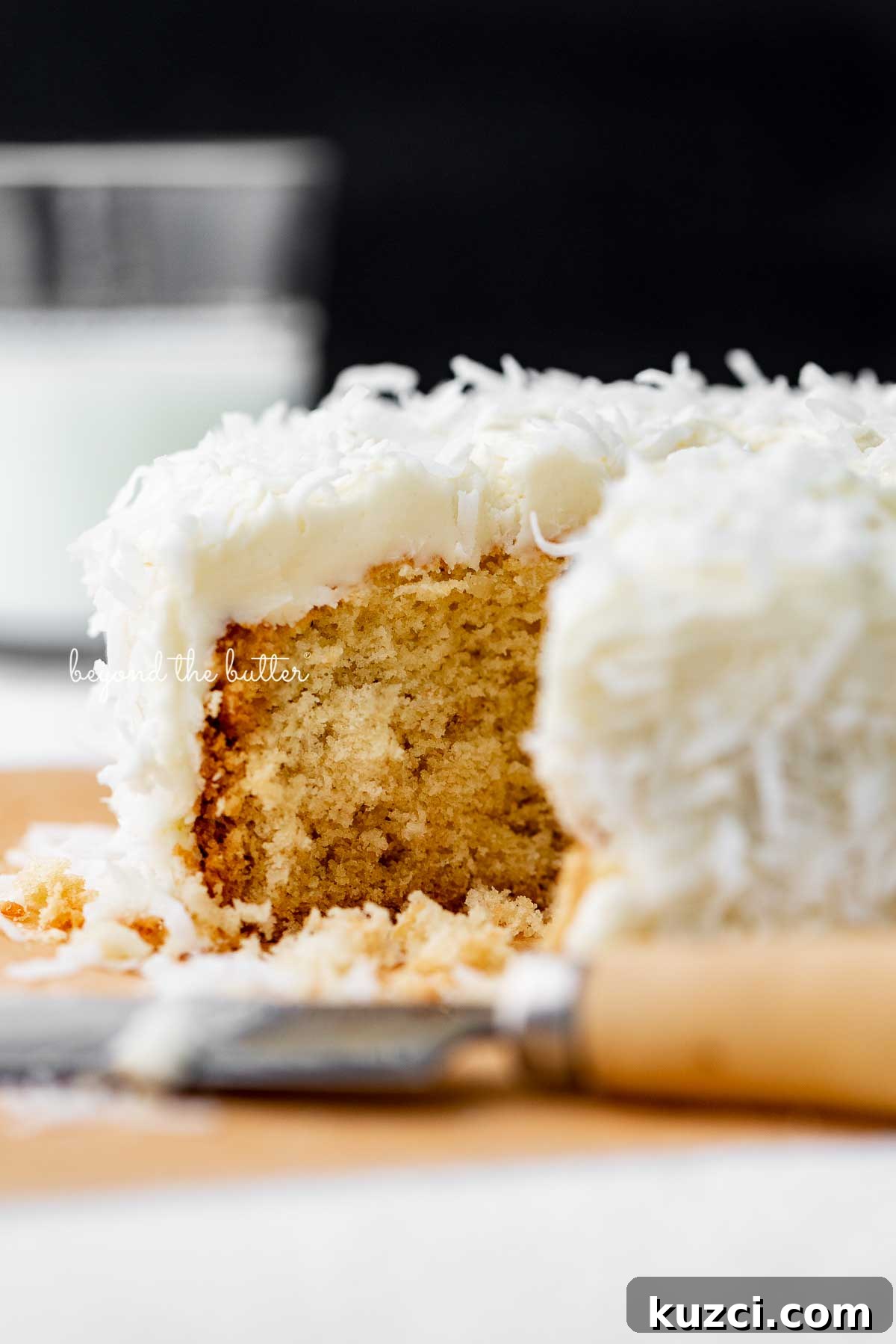 Moist Single Layer Coconut Cake Recipe 6 Sliced single layer coconut cake with black background | © Beyond the Butter®