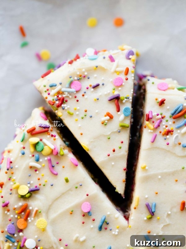 Moist Single Layer Coconut Cake Recipe 10 Cut slice of single layer funfetti cake partially removed from rest of the cake on white parchment paper.