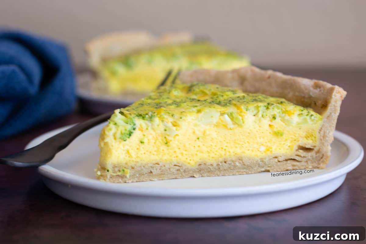 Gluten-Free Cheddar and Broccoli Quiche 3 Two slices of quiche on small white plates.
