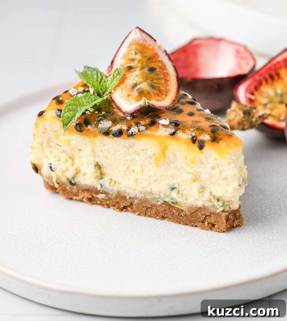 Passion Fruit Cheesecake Recipe with Tropical Glaze 6 One slice of cheesecake on a small white plate.