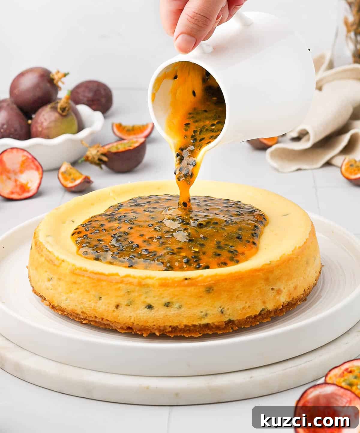 Passion Fruit Cheesecake Recipe with Tropical Glaze 7 Pouring the passion fruit coulis topping over the cheesecake.