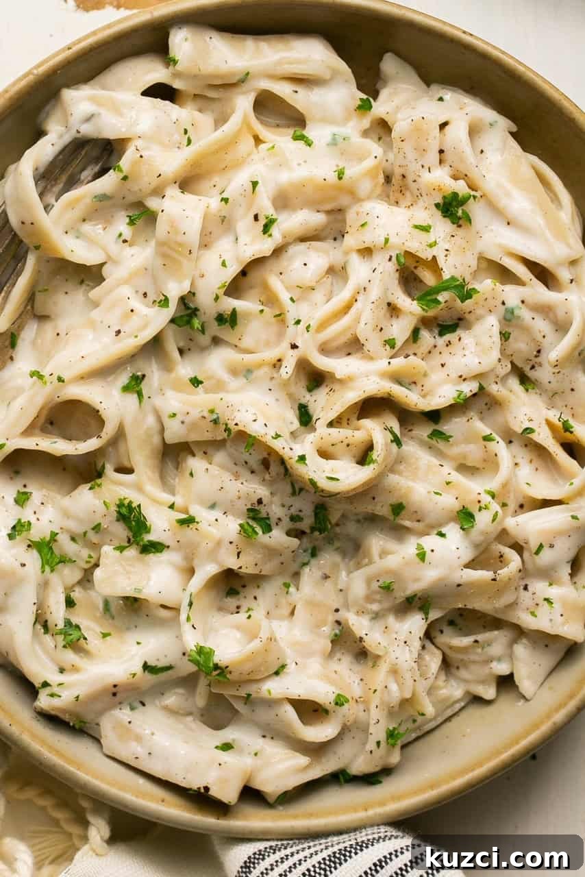 10-Minute High-Protein Cottage Cheese Alfredo Sauce 2 cottage cheese alfredo pasta in a bowl topped with parsley