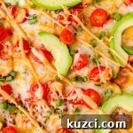 Simple Ground Turkey Recipes That Taste Delicious 2 close up of baked healthy ground turkey enchiladas garnished with cherry tomato slices, avocado slices, green onion and queso.