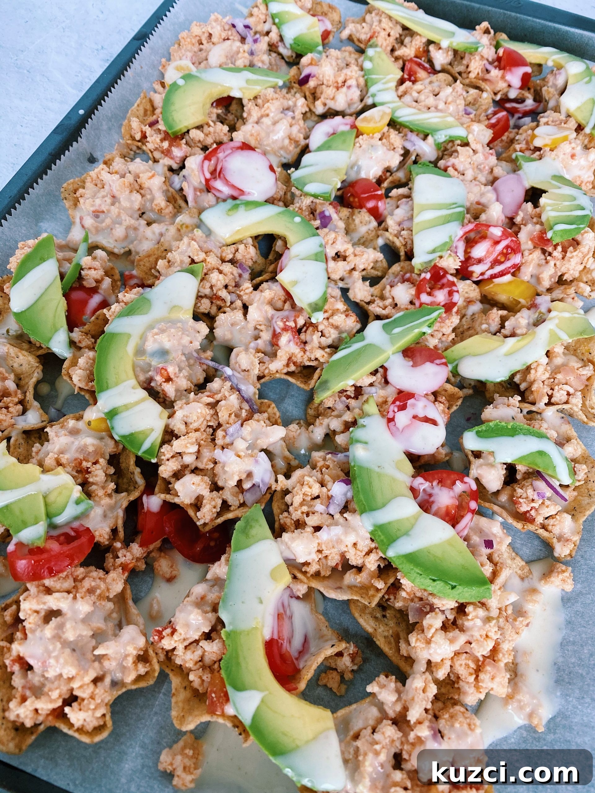 Simple Ground Turkey Recipes That Taste Delicious 17 sheet pan game day nachos with drizzled queso and topped with avocado slices.