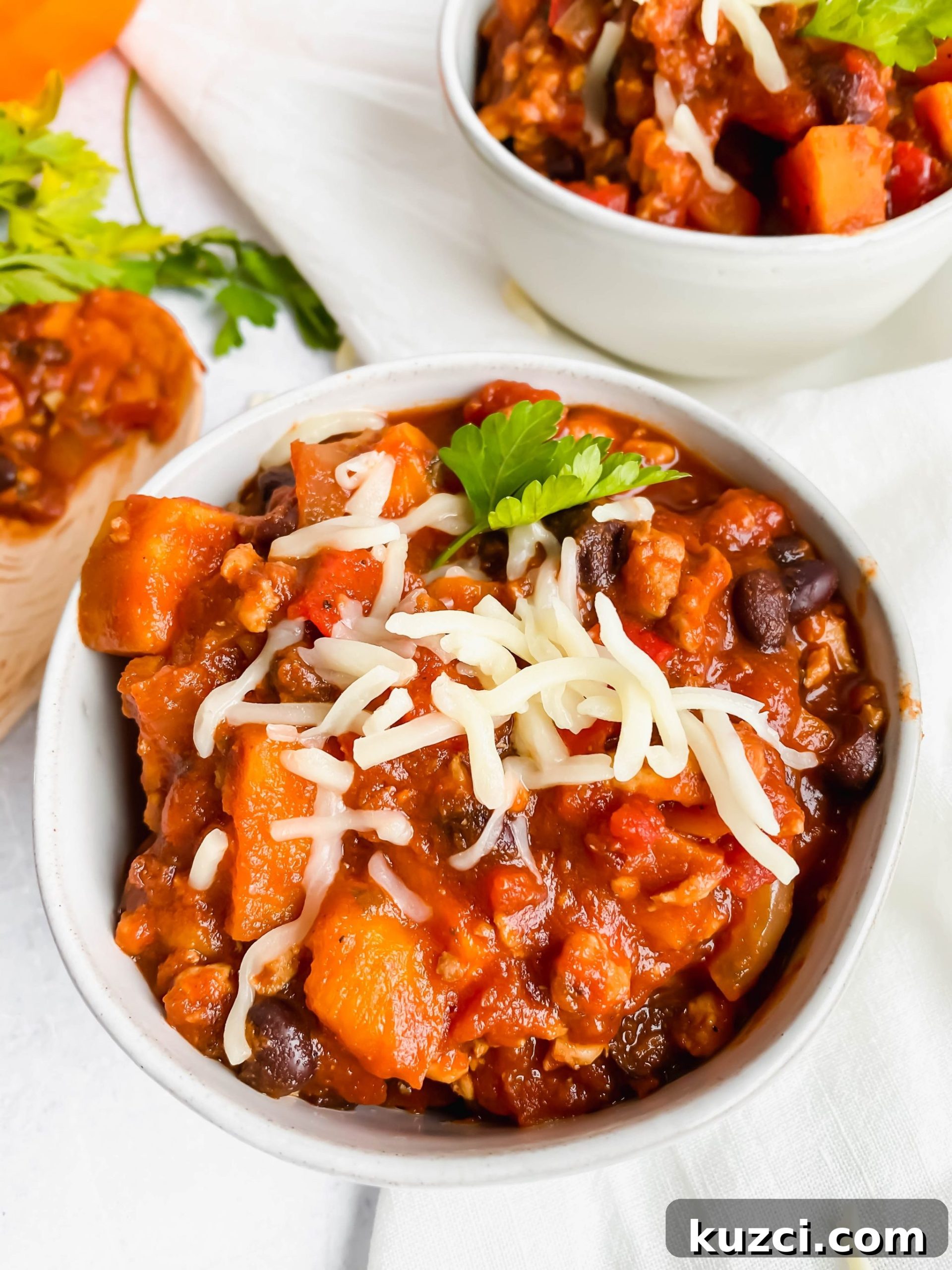 Simple Ground Turkey Recipes That Taste Delicious 23 sweet potato turkey chili topped with cheese and parsley.
