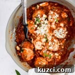 Simple Ground Turkey Recipes That Taste Delicious 10 Zesty Turkey Feta Meatballs in a gray skillet with a serving spoon.