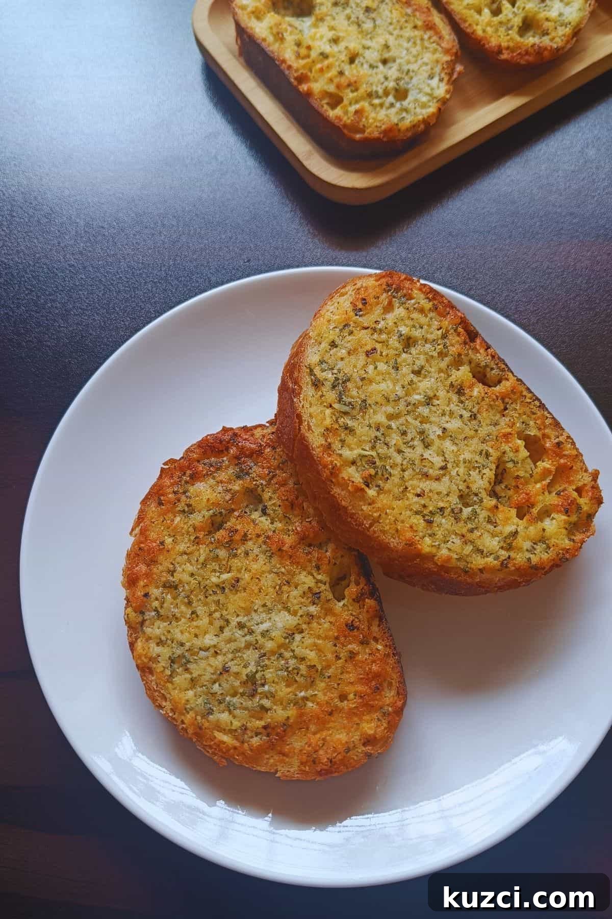 Crispy Air Fryer Garlic Bread Recipe 5 Image showing garlic bread toast served on a white plate.