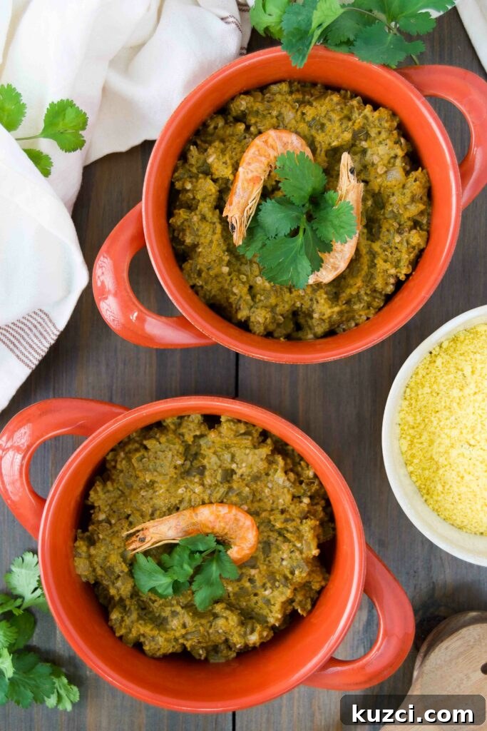 Caruru: Brazilian Shrimp and Okra Stew Recipe 7 Two orange crocks of caruru garnished with dried shrimp and cilantro on a wooden table