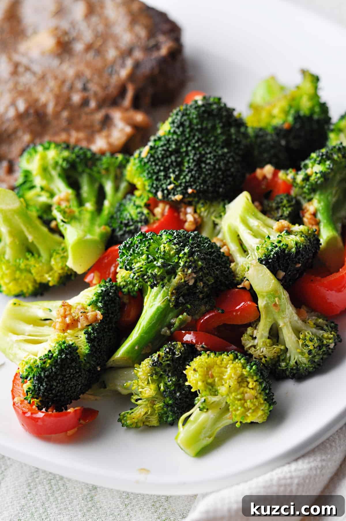 Cooked broccoli and red pepper on plate ready to eat.