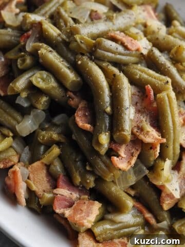 Green beans with onion and bacon on plate ready to eat.