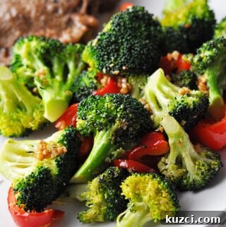 Cooked broccoli and red pepper on plate ready to eat.
