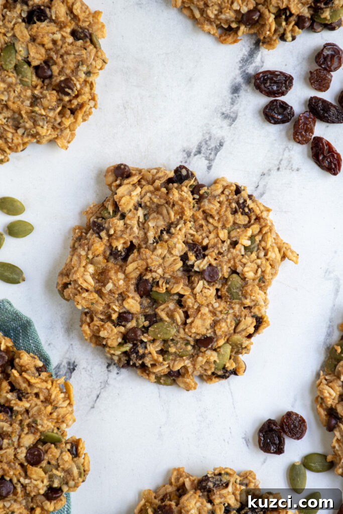 Protein-Packed Breakfast Cookies for Busy Mornings 2 A breakfast cookie laying on a tabletop made up of oats, seeds, and raisins.