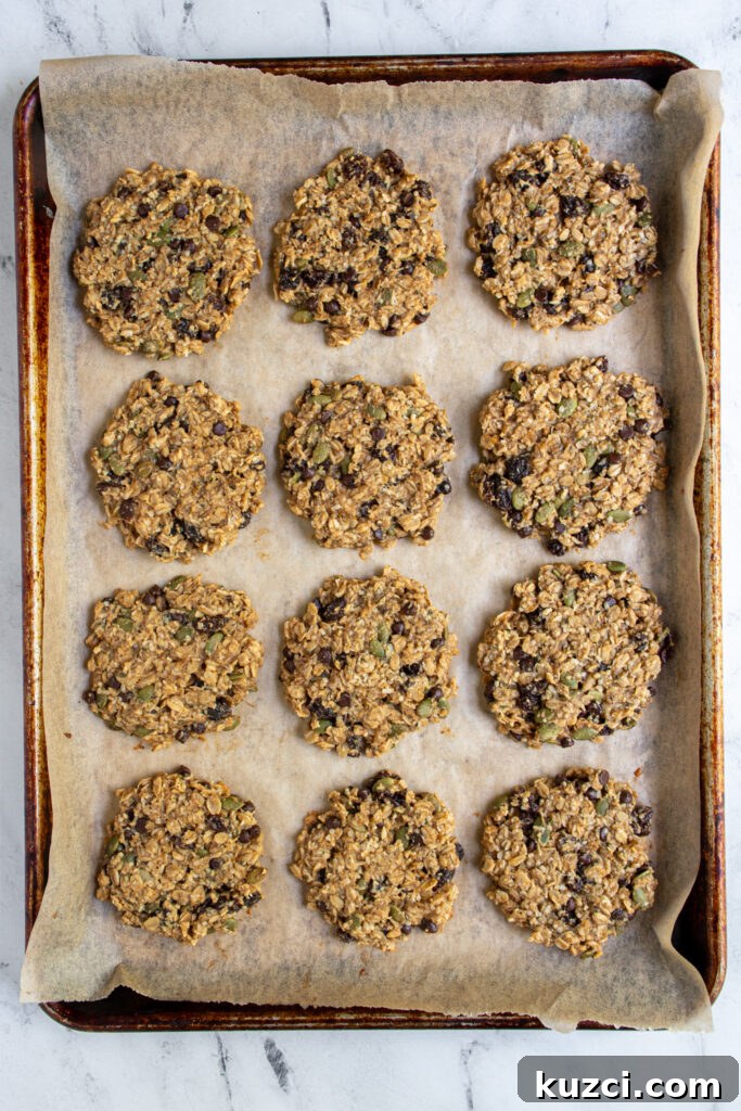 Protein-Packed Breakfast Cookies for Busy Mornings 6 A sheet pan with parchment paper with 12 freshly baked banana oat breakfast cookies.