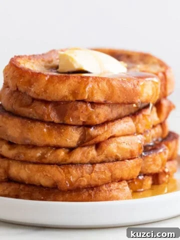 Stack of vegan French toast on a plate with maple syrup and vegan butter.