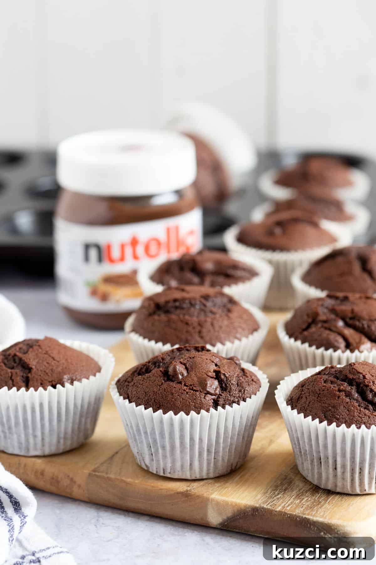 Nutella Chocolate Muffins Recipe 5 Nutella muffins on a wooden board.
