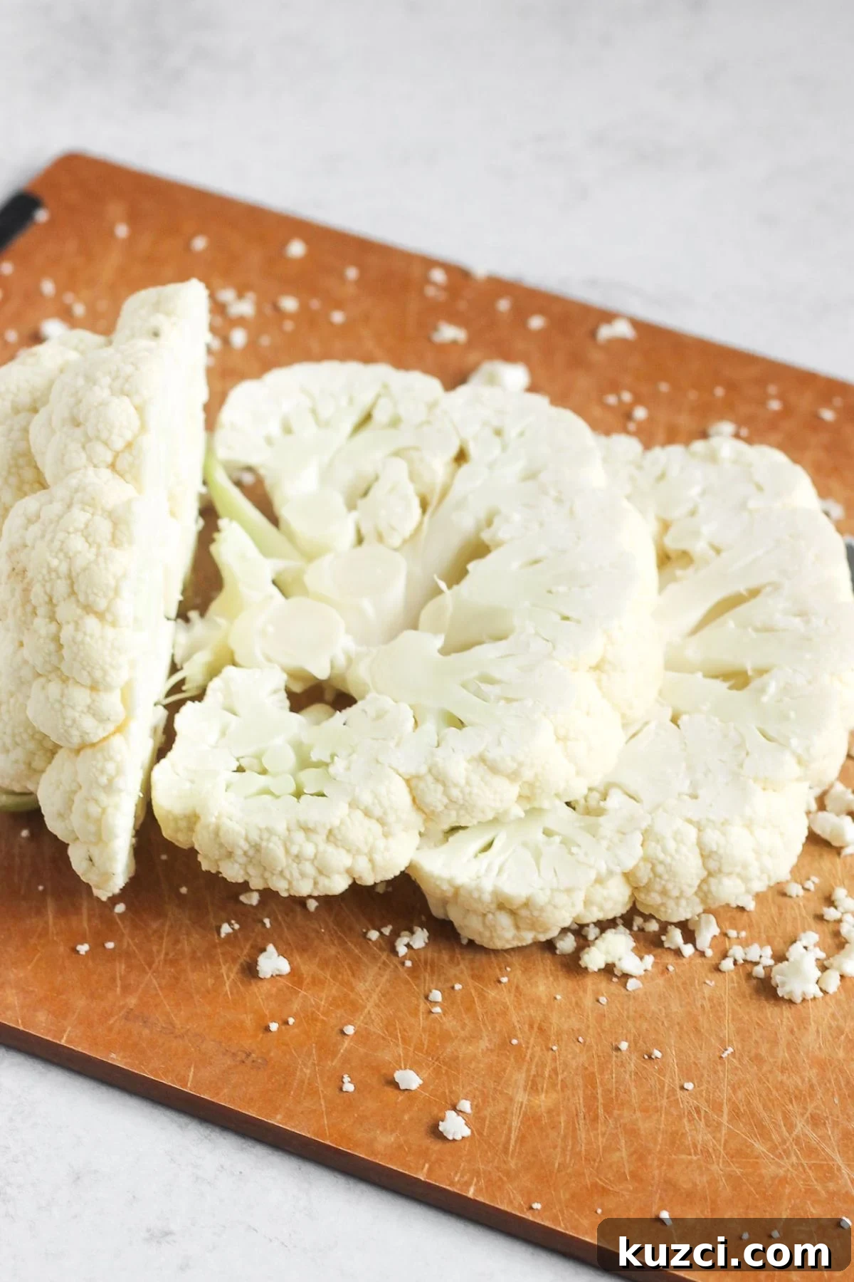 Sliced cauliflower steaks on a cutting board.